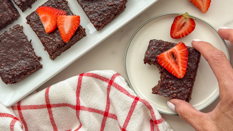 hand holding brownie with strawberry