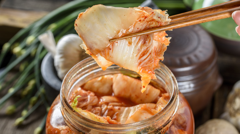 Kimchi being lifted from a jar