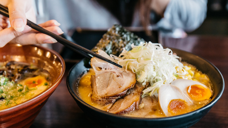 Bowl of chashu ramen being eaten with chopsticks