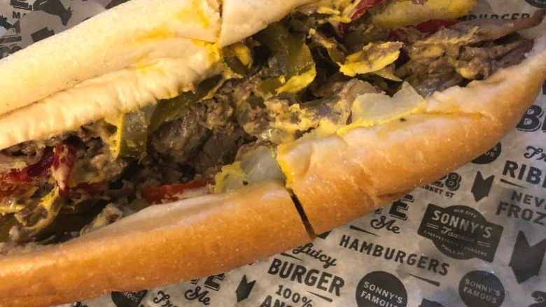 a cheesesteak from sonny's famous cheesesteaks full of peppers, steak, and onions