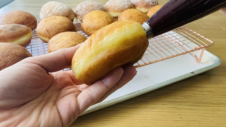 hand holding jelly doughnut