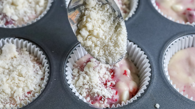 streusel topping being spooned onto muffins