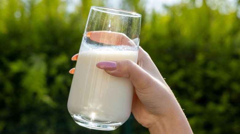 woman holding glass of milk outside