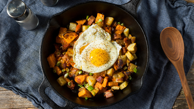 breakfast hash topped with an egg in a skillet