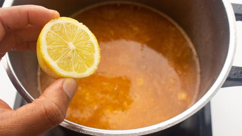 putting lemon into lentil soup