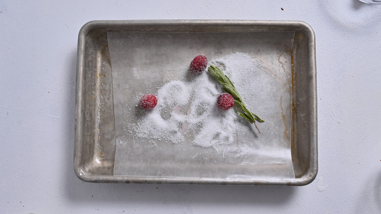 sugared cranberries and rosemary on sheet tray