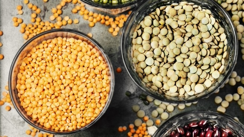 Overview of dry red and green lentils in bowls