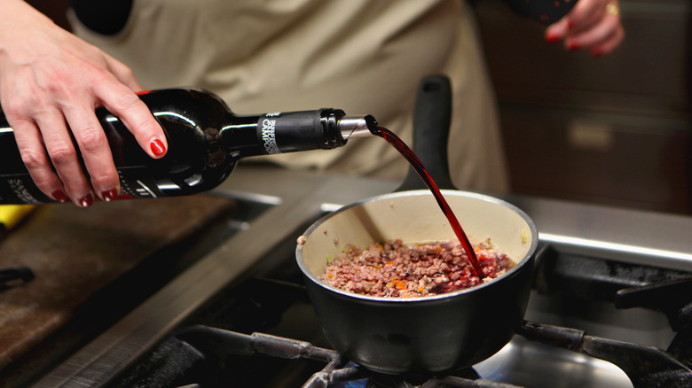 Pouring red wine into pot 