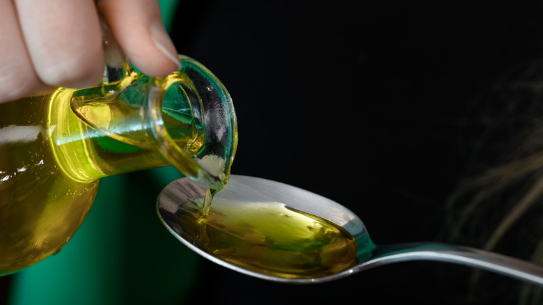 Cooking oil pouring into spoon.