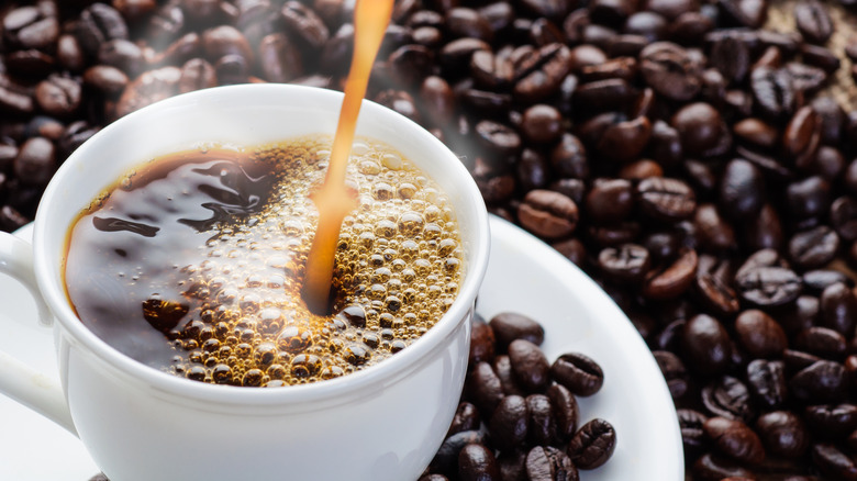 Hot cup of coffee with coffee beans