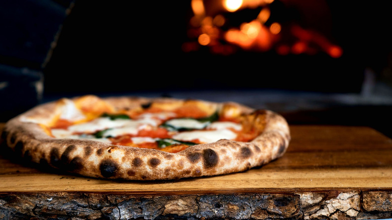 Pizza in front of wood oven