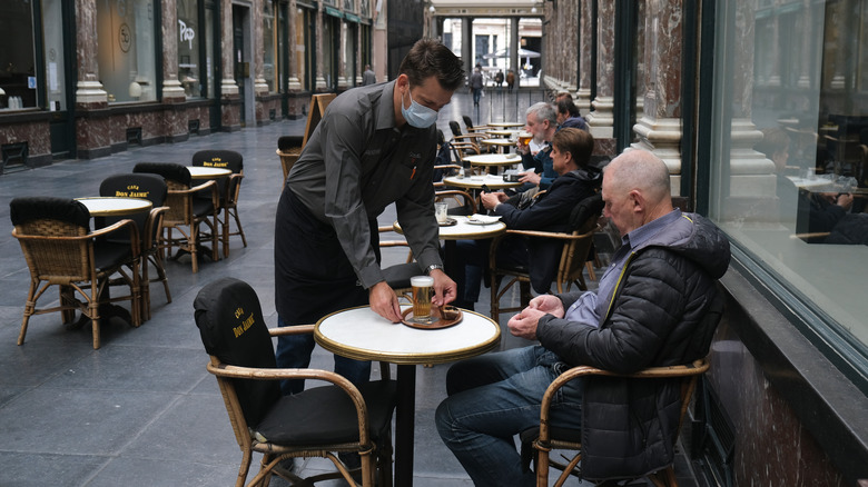 Waiter serving food to customer