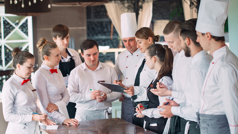 Restaurant employees gather with chef 