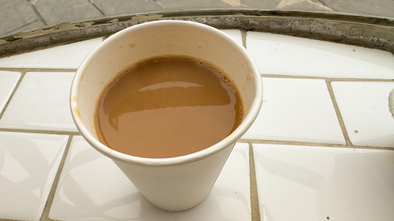 Hot coffee with milk on white subway tiles