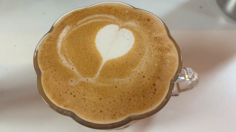 Teacup with espresso shot and steamed milk heart on white table