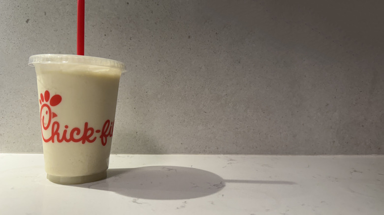 Chick-fil-A key lime frosted lemonade drink cup with straw on white counter.