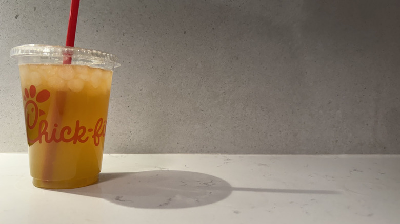 Chick-fil-A key lime lemonade Sunjoy drink cup with straw on white counter.