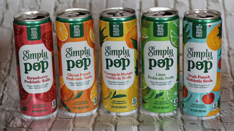 Open Simply Pop cans on brick background