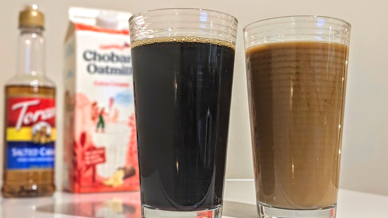 Two glasses of iced coffee with oat milk and Torani syrup in the background.