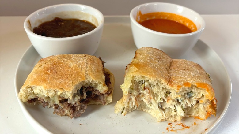 two panera ciabatta dippers in front of bowls of soup on white plate