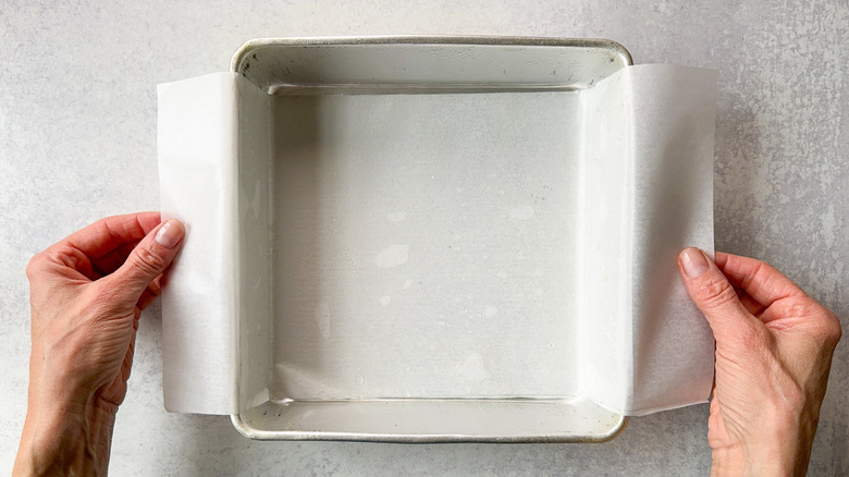 Square baking pan lined with parchment overhang