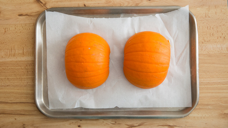 pumpkin halves on baking sheet