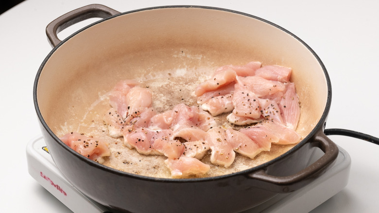 chicken frying in pan