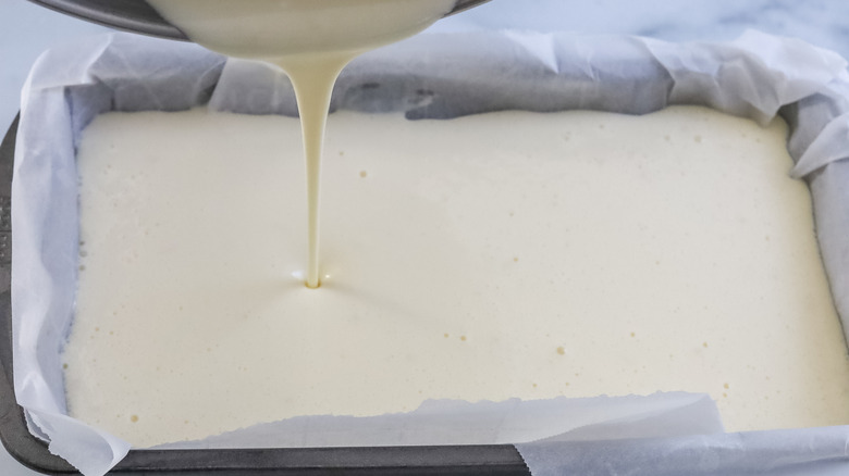 Batter being poured into a loaf pan