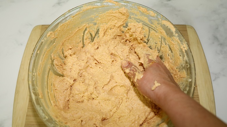 hand mixing masa for tamales