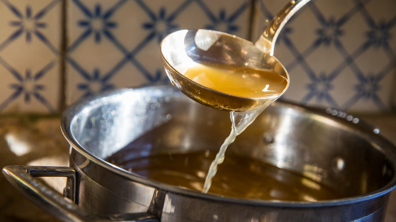 ladle over pot of broth