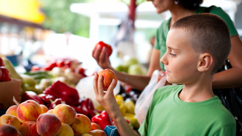 selecting peaches at store