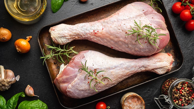 Raw turkey thighs with spices on a cutting board