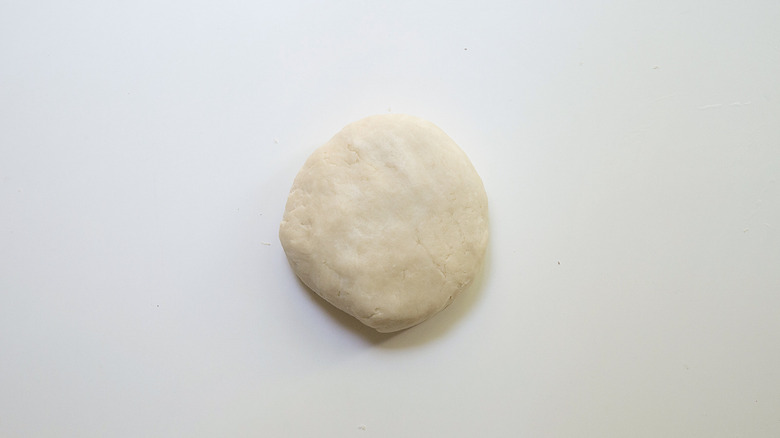 flattened dough ball on table