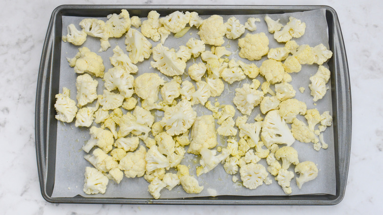 oil covered cauliflower florets on baking pan