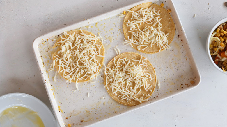tortillas on a baking sheet, topped with cheese