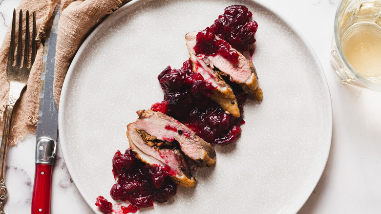 Sliced stuffed duck breasts with sauce on a plate