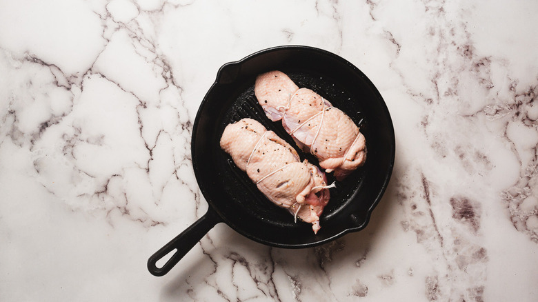 Two raw duck breasts in pan