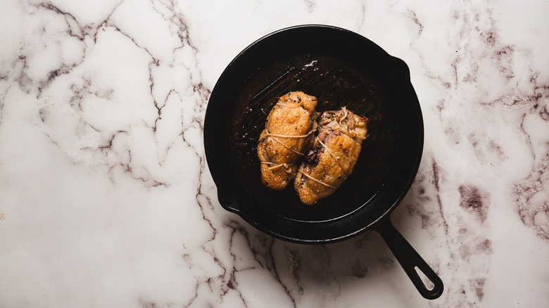 Two cooked duck breasts in pan