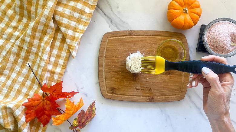 brushing garlic bulb with oil