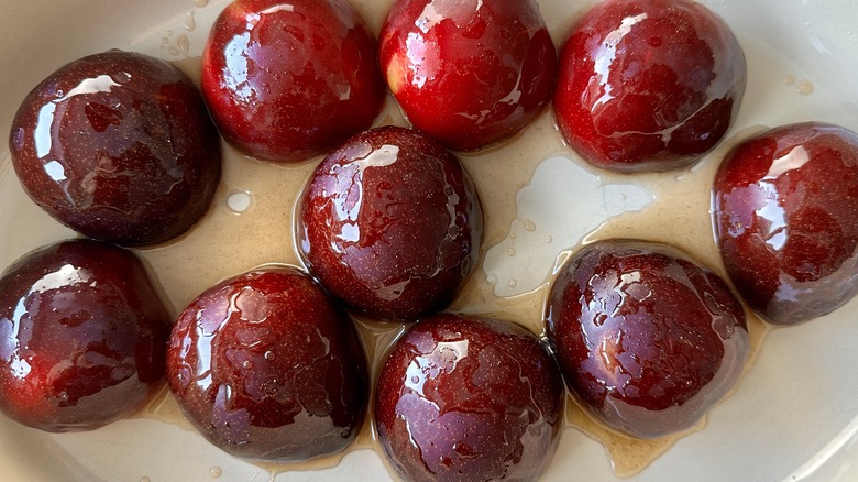 halved plums in baking dish