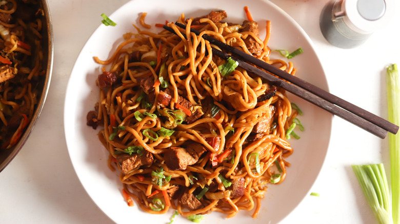 roasted pork lo mein with chopsticks on plate