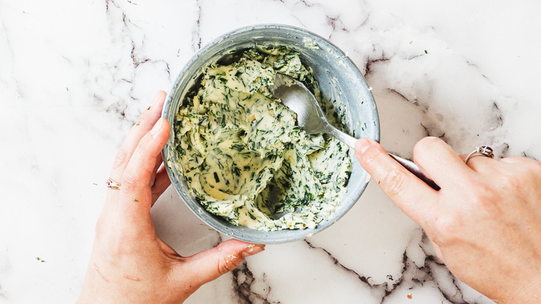 Mixing herb butter with spoon