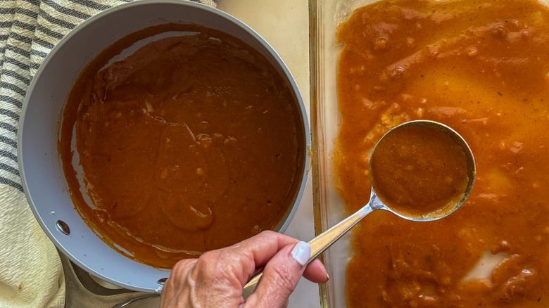 hand using ladle for sauce