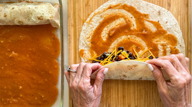 hands rolling up tortillas