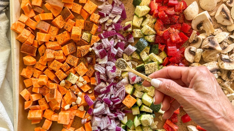 hand adding pepper to sheet