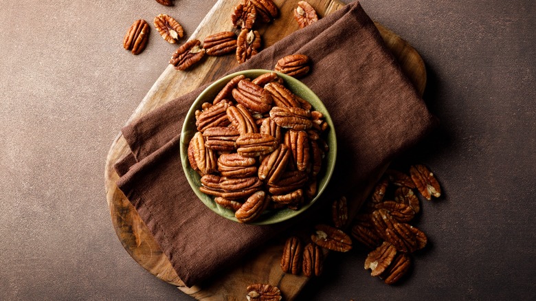 scattered pecans on a pink background