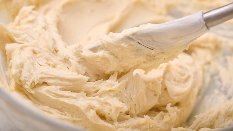 stirring buttercream in bowl