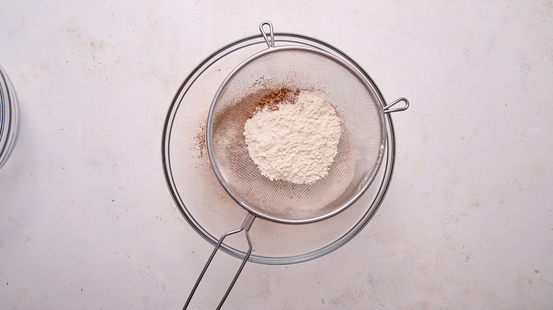 sifting dry ingredients into bowl