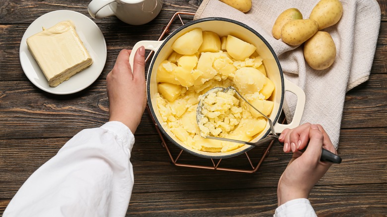 Mashing potato in pot