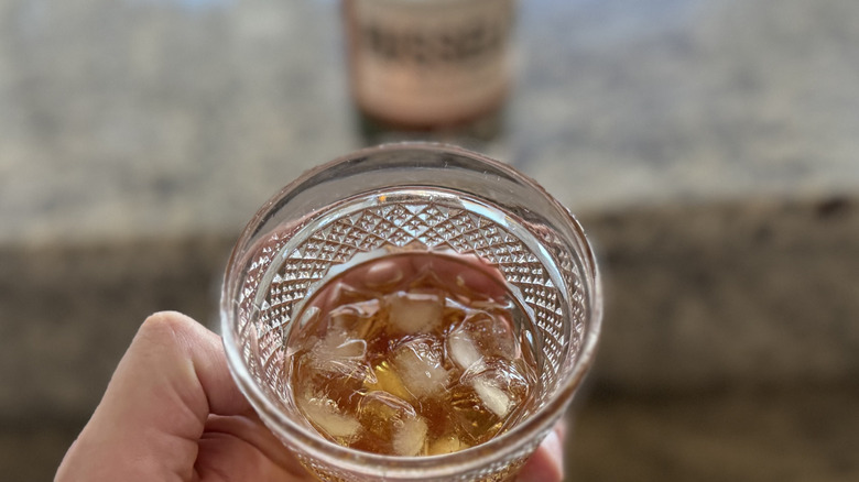 Hand holding Russell's Reserve rye on the rocks